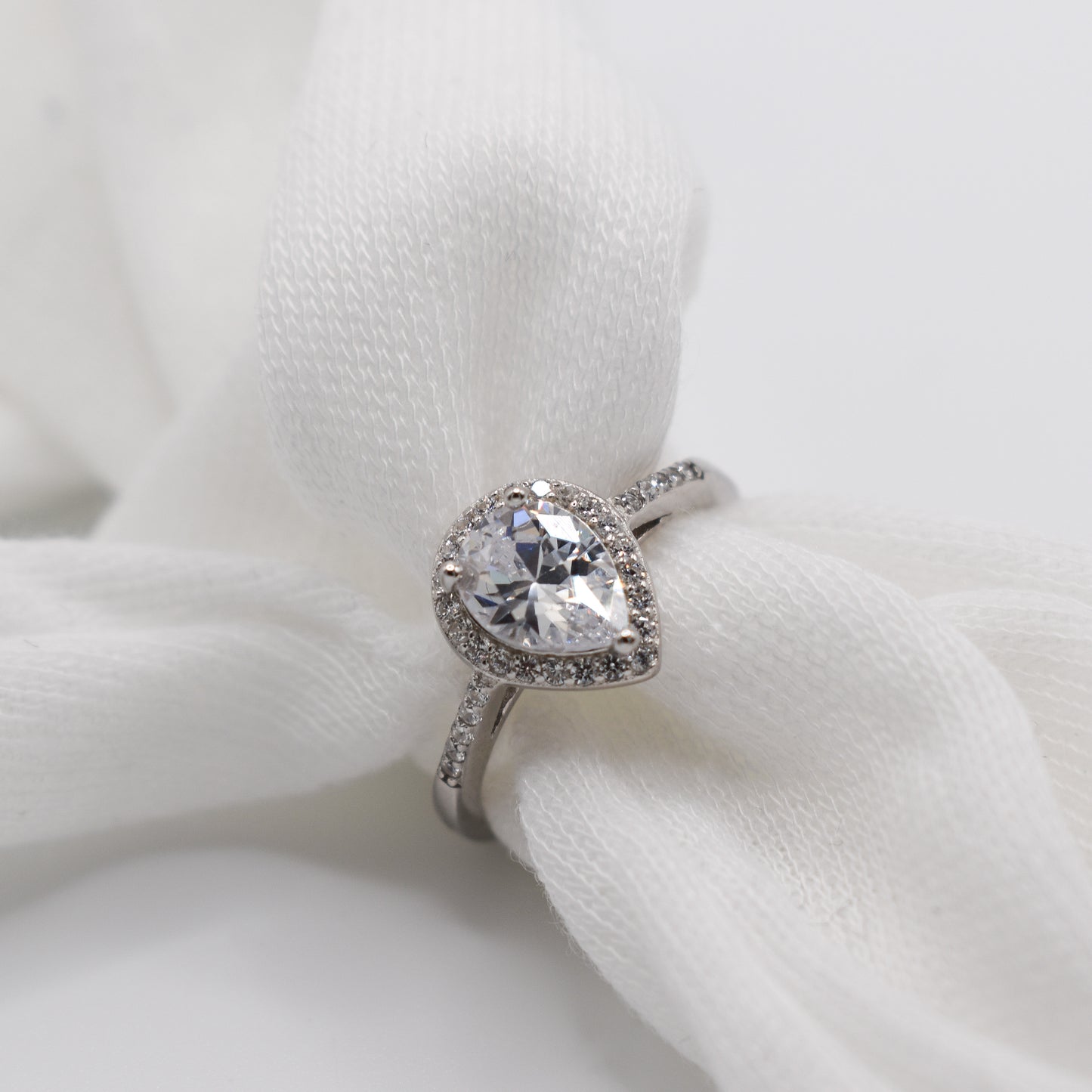 Pear shaped cut clear cubic zirconia gemstone on a silver cubic zirconia band ring.