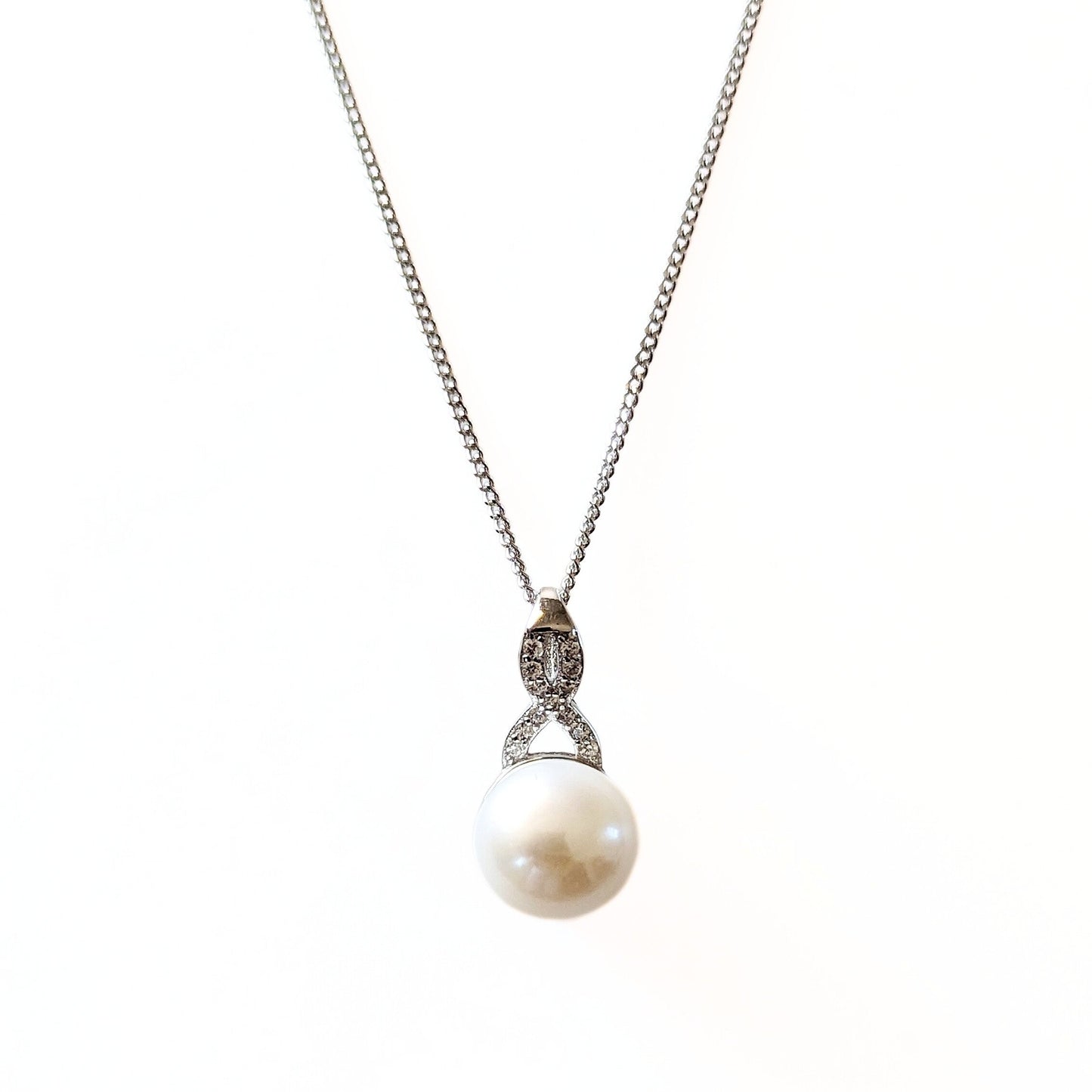 A beautiful sterling silver necklace featuring a freshwater pearl and cubic zirconia pendant. 