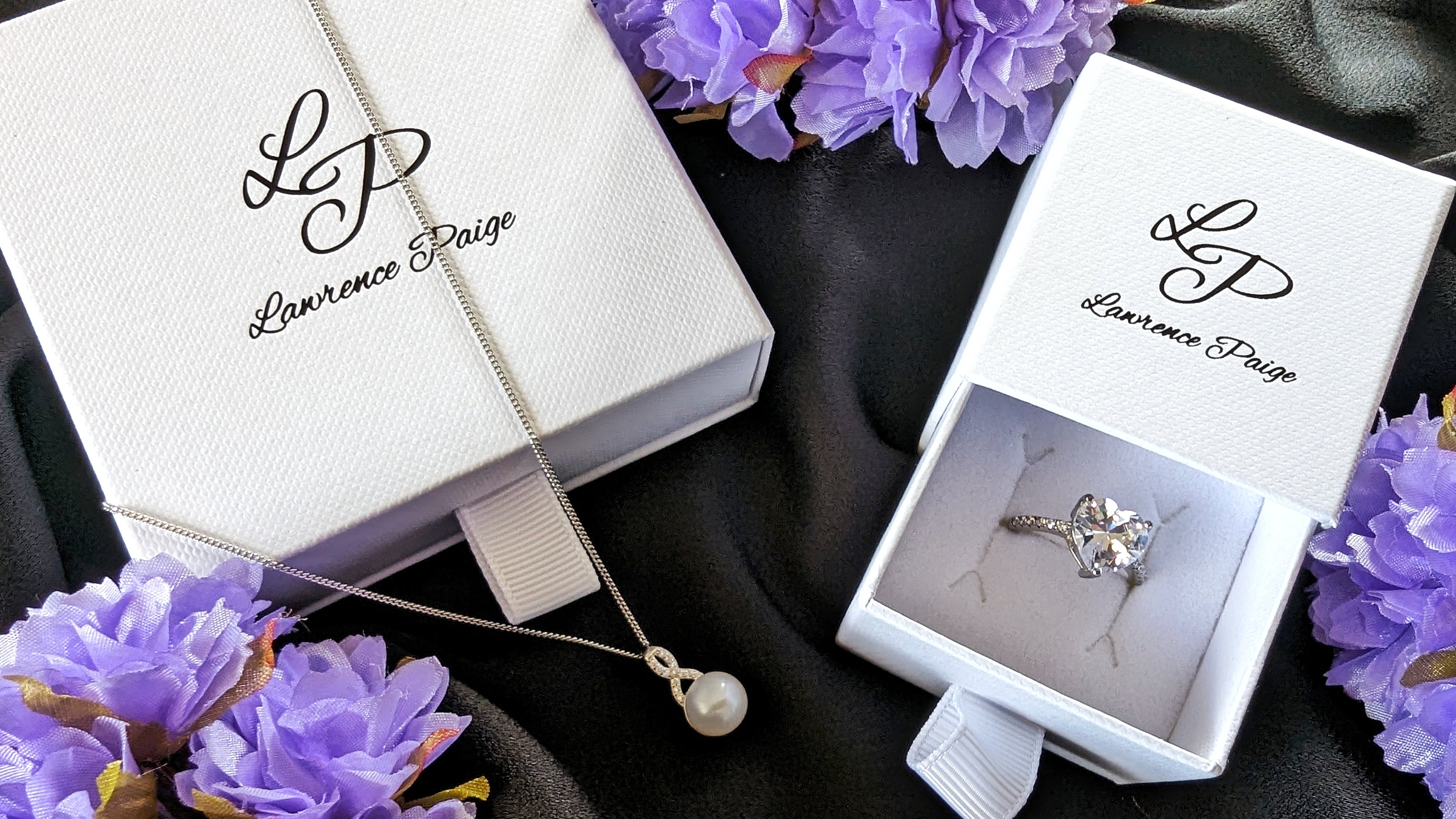 A necklace and ring with the Lawrence Paige packaging.