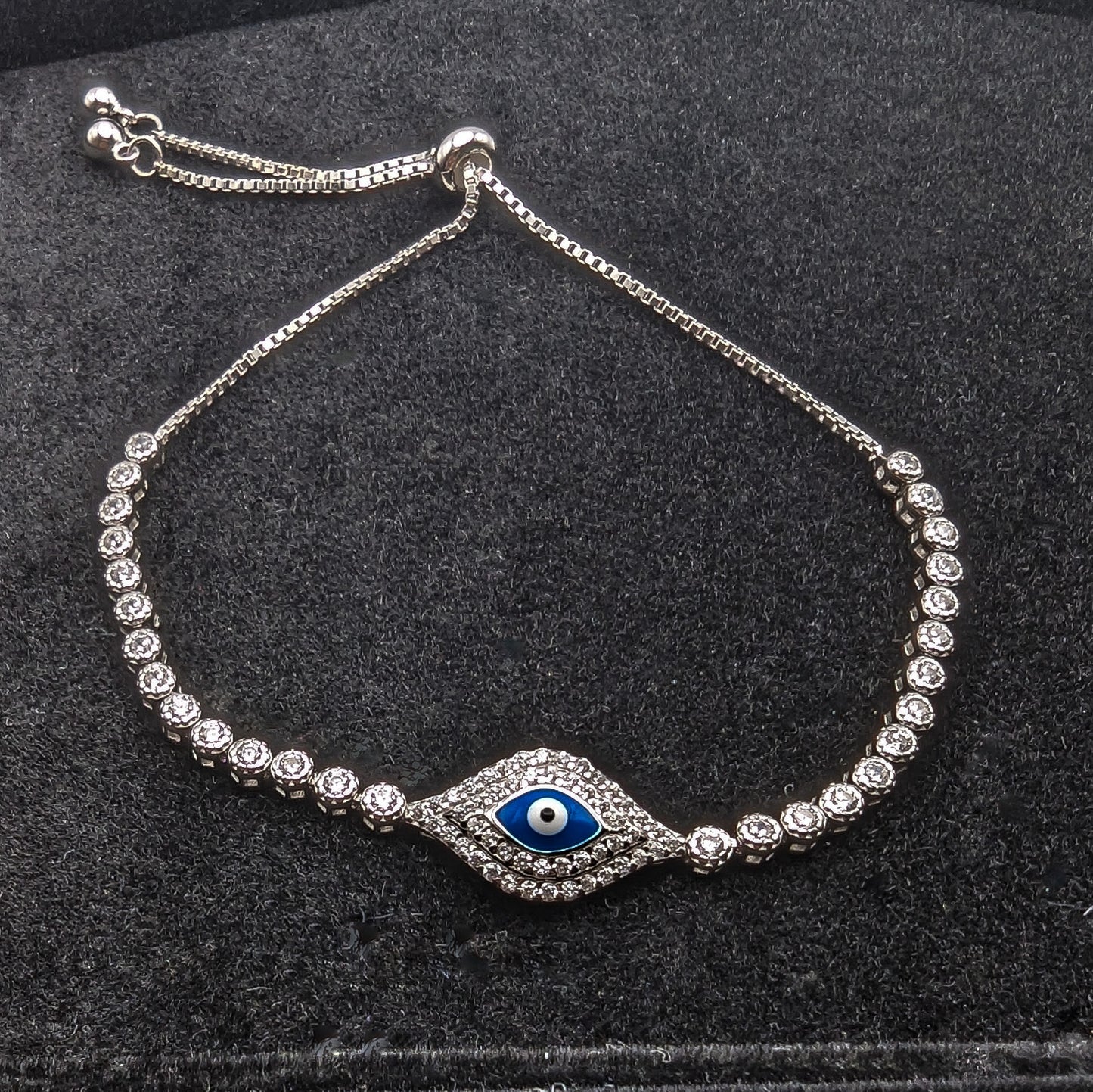 Stunning sterling silver and cubic zirconia bracelet with evil eye design, it features a toggle chain for a tailored fit.